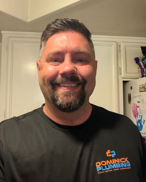Casey Dominick, founder of Dominick Plumbing, in a company shirt